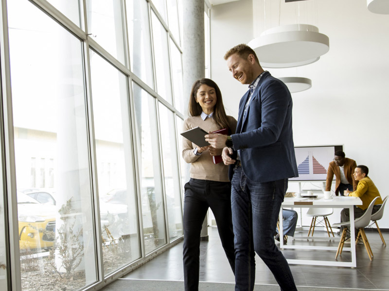 a happy manager checking a checklist with his assistant in a sunlit room