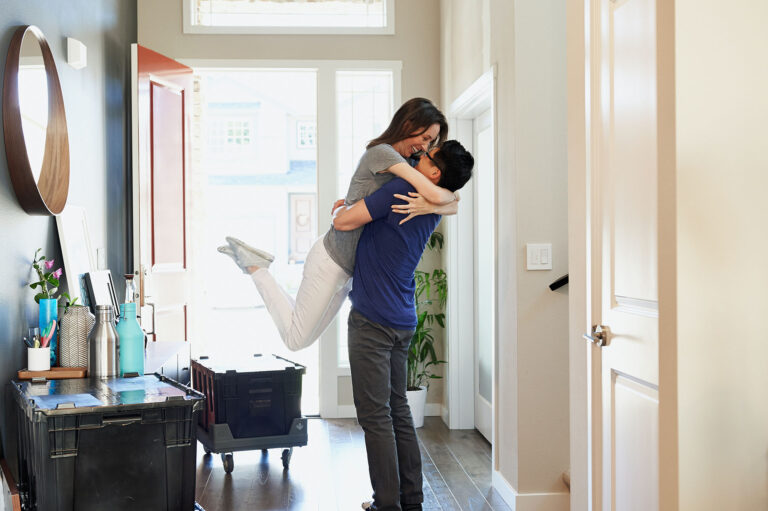 a woman jumping onto her husband hugging him because of happiness