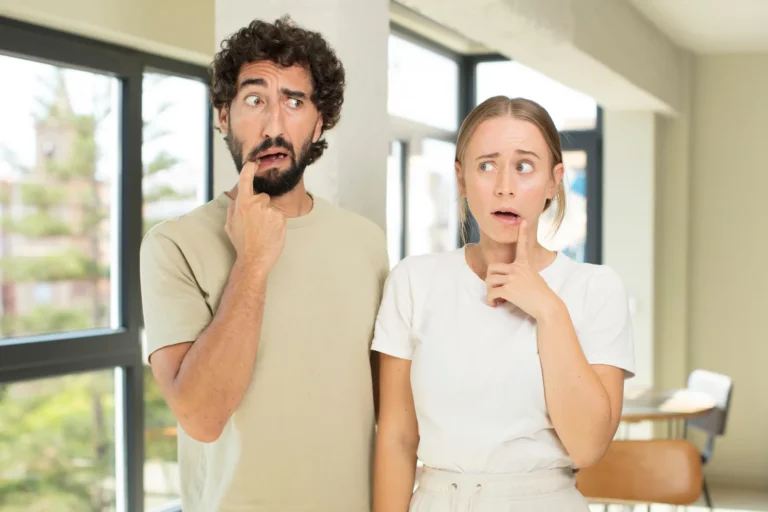 a man and woman making funny confused faces in a sunny room
