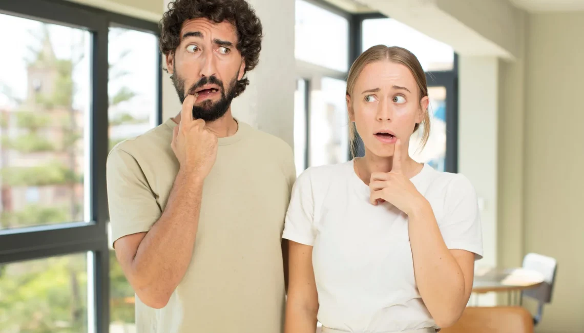 a man and woman making funny confused faces in a sunny room